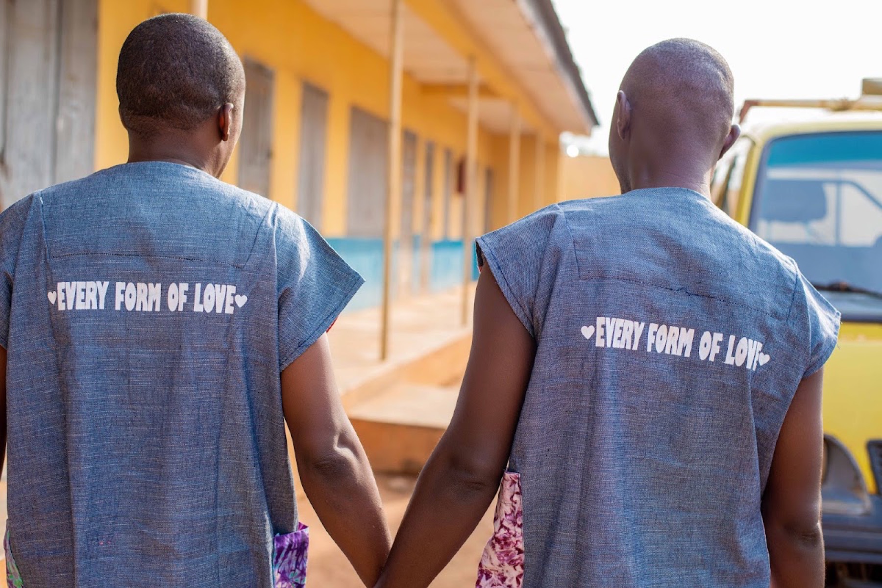 Two men from behind, their shirts reading Every form of love.