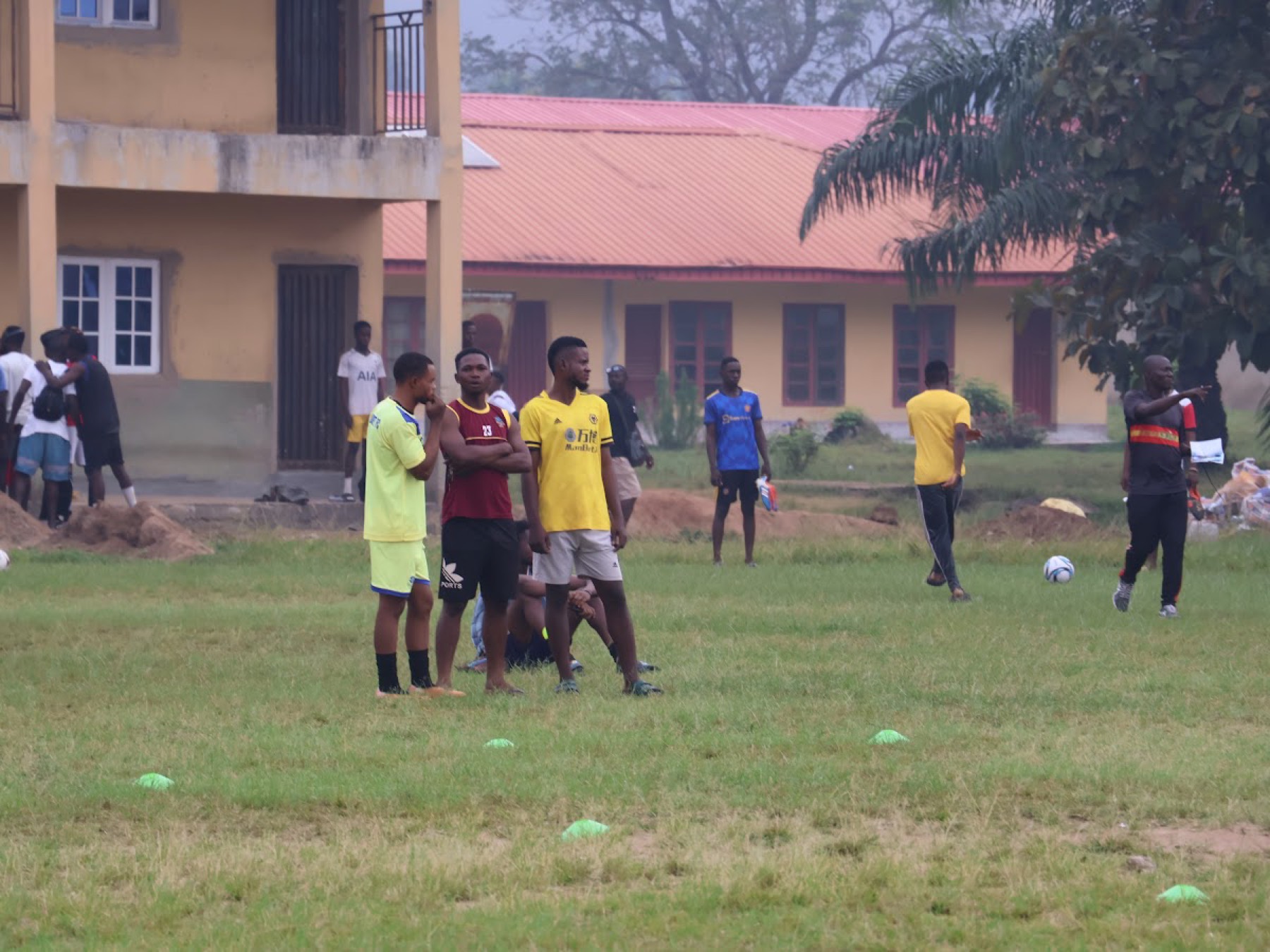 Young people in football kits on a community field.