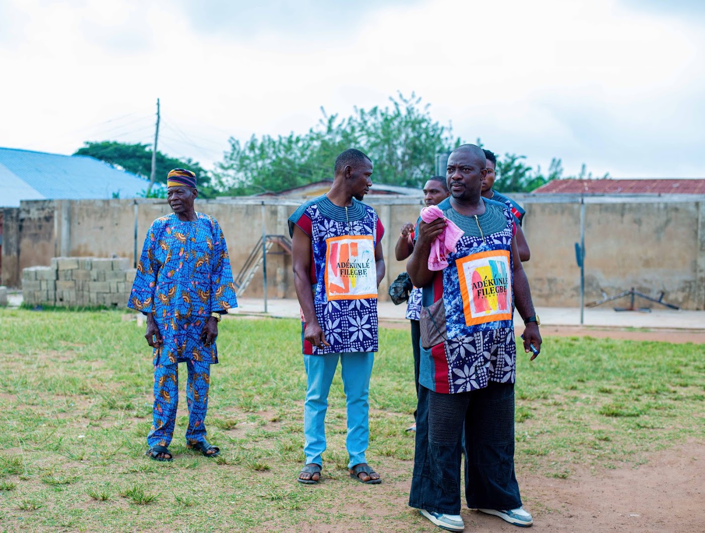 Men in foundation vests standing on a grass field.